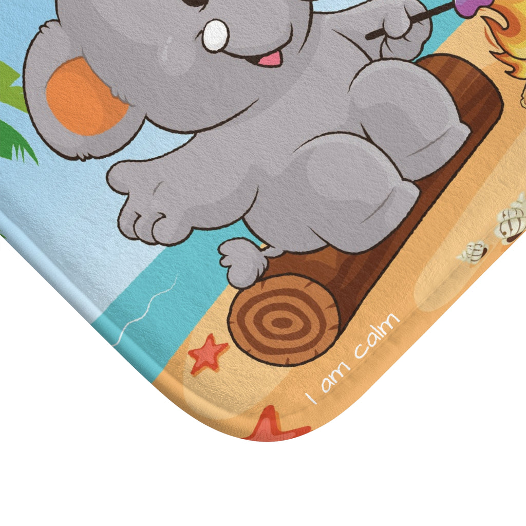 A close-up of a corner of the bath mat with a scene of an elephant having a bonfire on the beach.