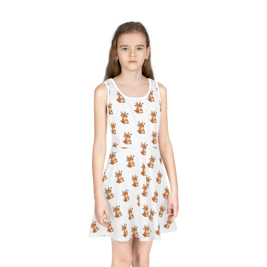 Front-view of a girl wearing a sleeveless white dress with a repeating pattern of a kangaroo.