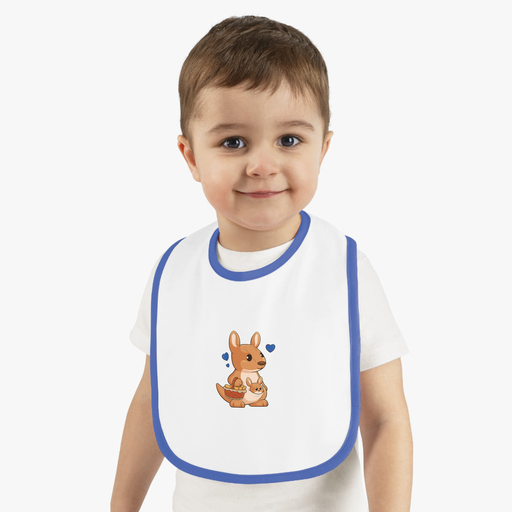 A little boy wearing a white baby bib with royal blue trim and a small picture of a kangaroo.