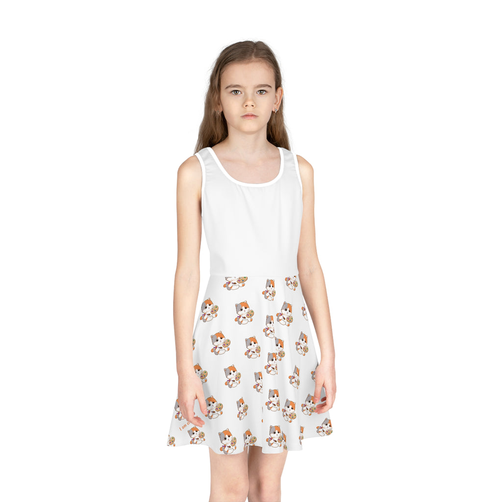 Front-view of a girl wearing a sleeveless white dress with a white top and a repeating pattern of a cat on the skirt.