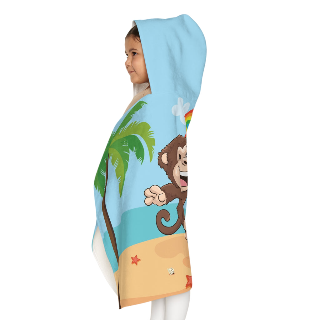 Left side-view of a girl wearing a hooded towel and holding it closed around her. The towel has a scene of a monkey playing volleyball on the beach, a rainbow in the background, and the phrase "I am fun" along the bottom.