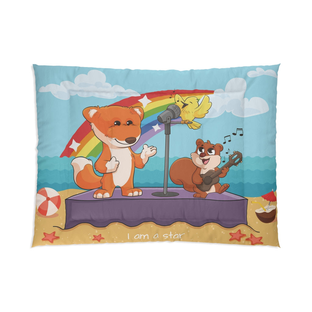 A 68 by 92 inch bed comforter with a scene of a fox singing with a bird and squirrel on a stage on the beach, a rainbow in the background, and the phrase "I am strong" along the bottom.