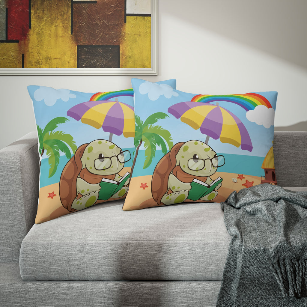 Two pillows sitting on a grey couch. The pillows have on pillowcases with a scene of a turtle reading a book under an umbrella on the beach, a rainbow in the background, and the phrase "I am smart" along the bottom.