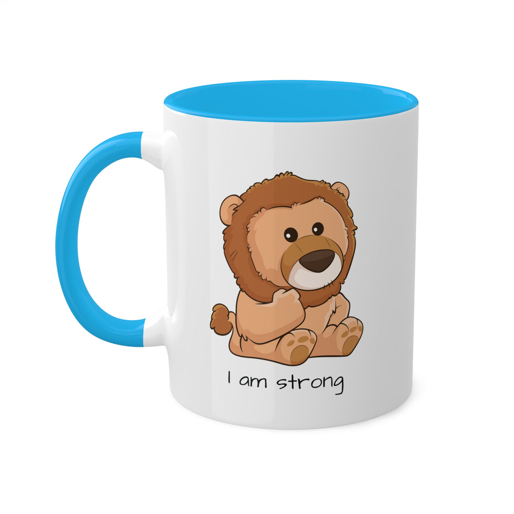 A white mug with a light blue handle and interior and a picture of a lion that says I am strong.
