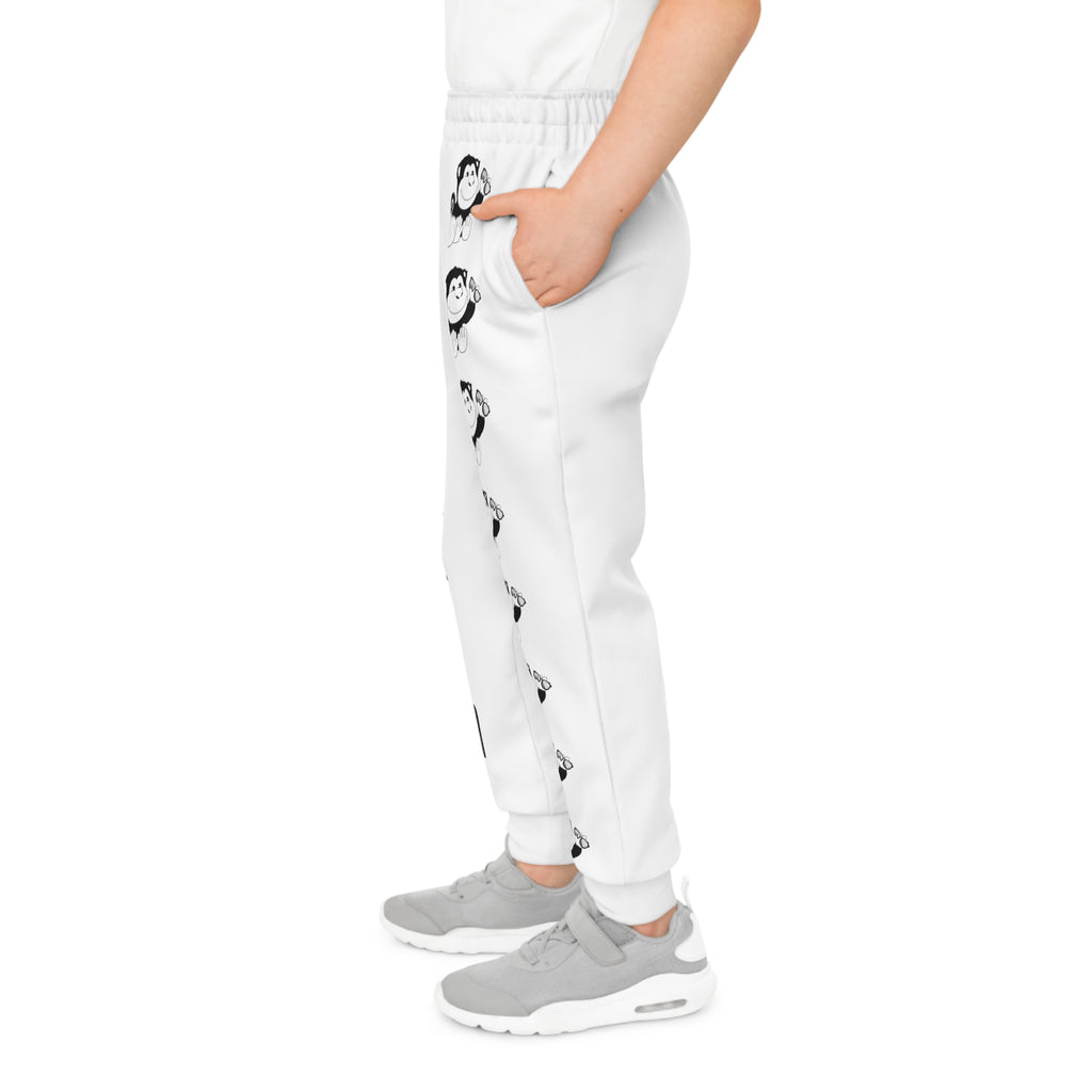 Left side-view of a boy wearing white sweatpants with a line of black and white monkeys down the front left leg.