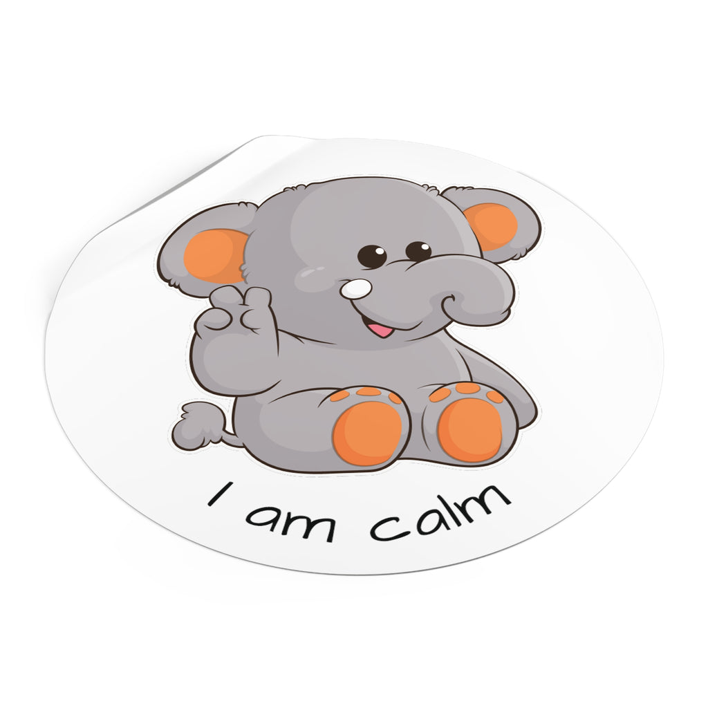 A 5 by 5 inch round white vinyl sticker with a picture of an elephant that says I am calm. The edge of the sticker is curled up.