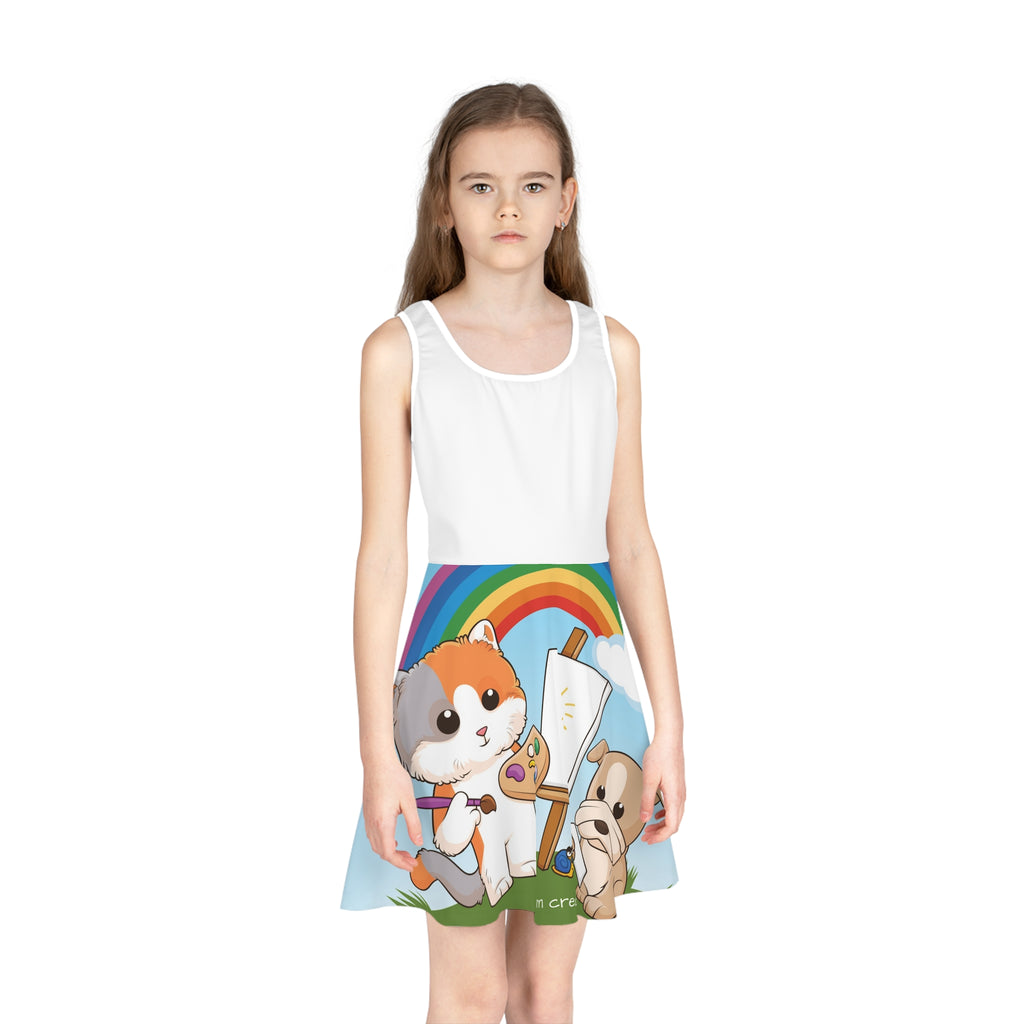 Front-view of a girl wearing a sleeveless dress. The dress has a white top and the skirt features a scene of a cat painting on a canvas next to a dog and the phrase "I am creative" along the bottom.