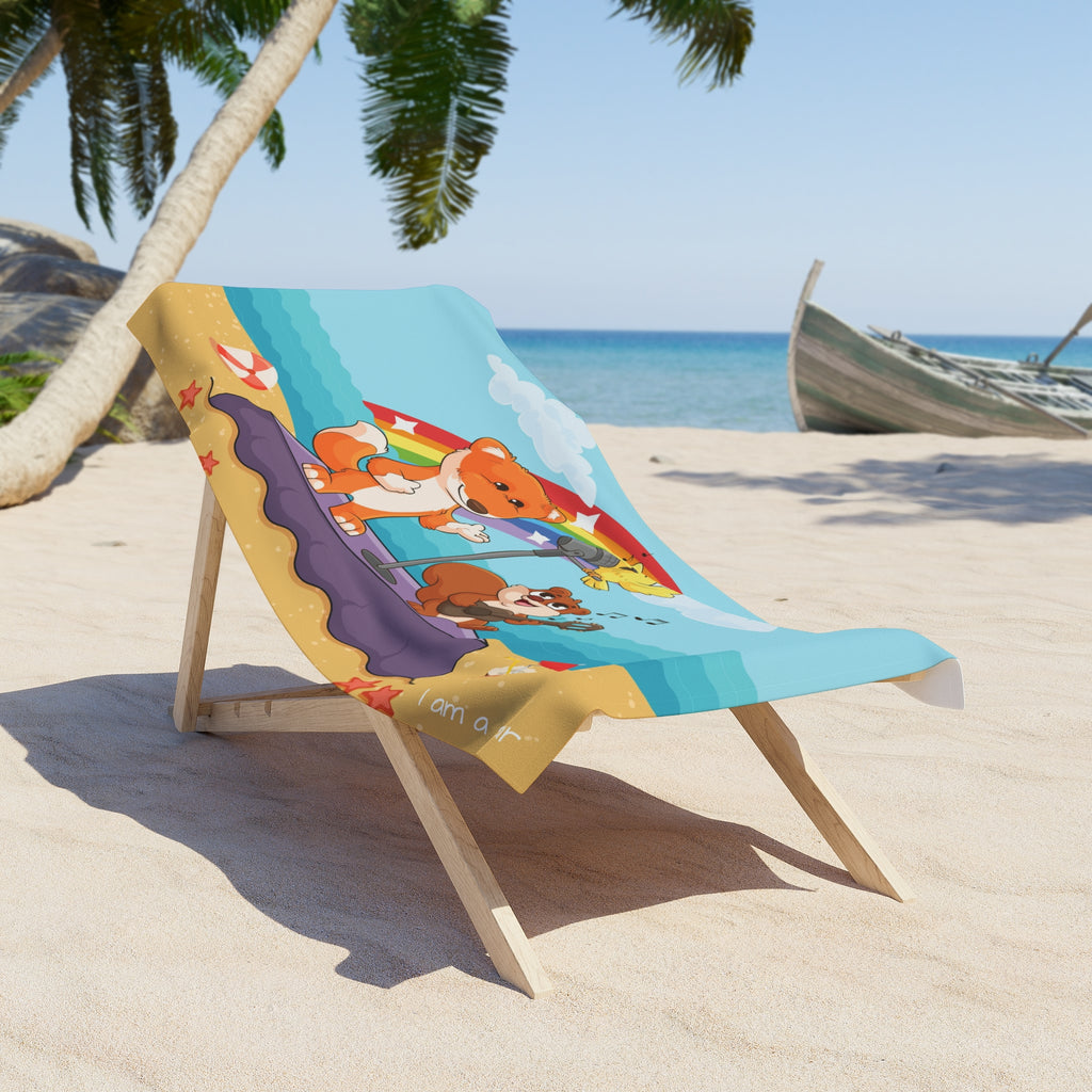 A 30 by 60 inch beach towel draped over a chair on a beach. The towel has a scene of a fox singing with a bird and squirrel on a stage on the beach, a rainbow in the background, and the phrase "I am a star" along the bottom.