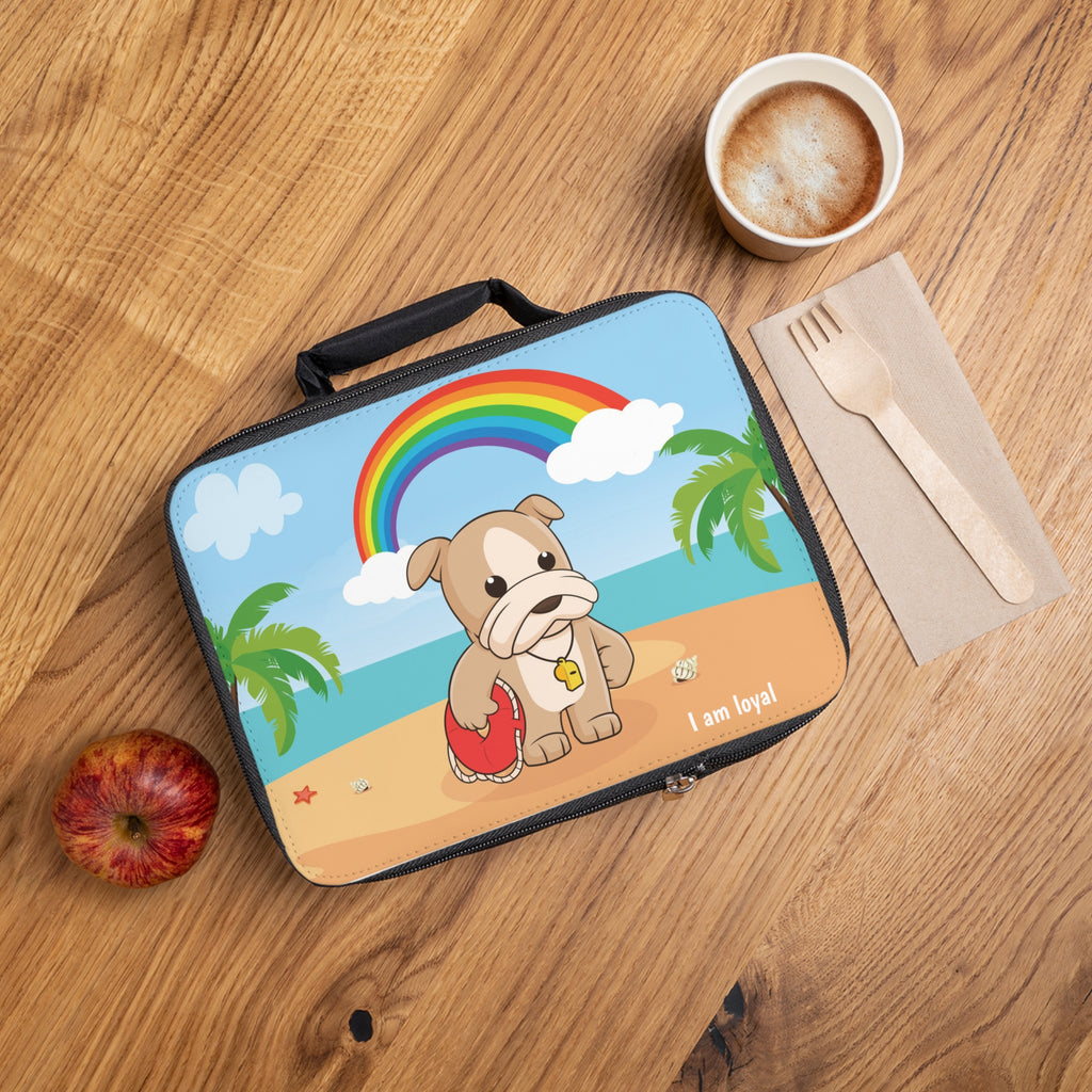 A lunch bag laying closed on a table next to a cup, fork, and apple. The lunch bag has a scene on the front of a dog lifeguard standing on the beach, a rainbow in the background, and the phrase "I am loyal" along the bottom.