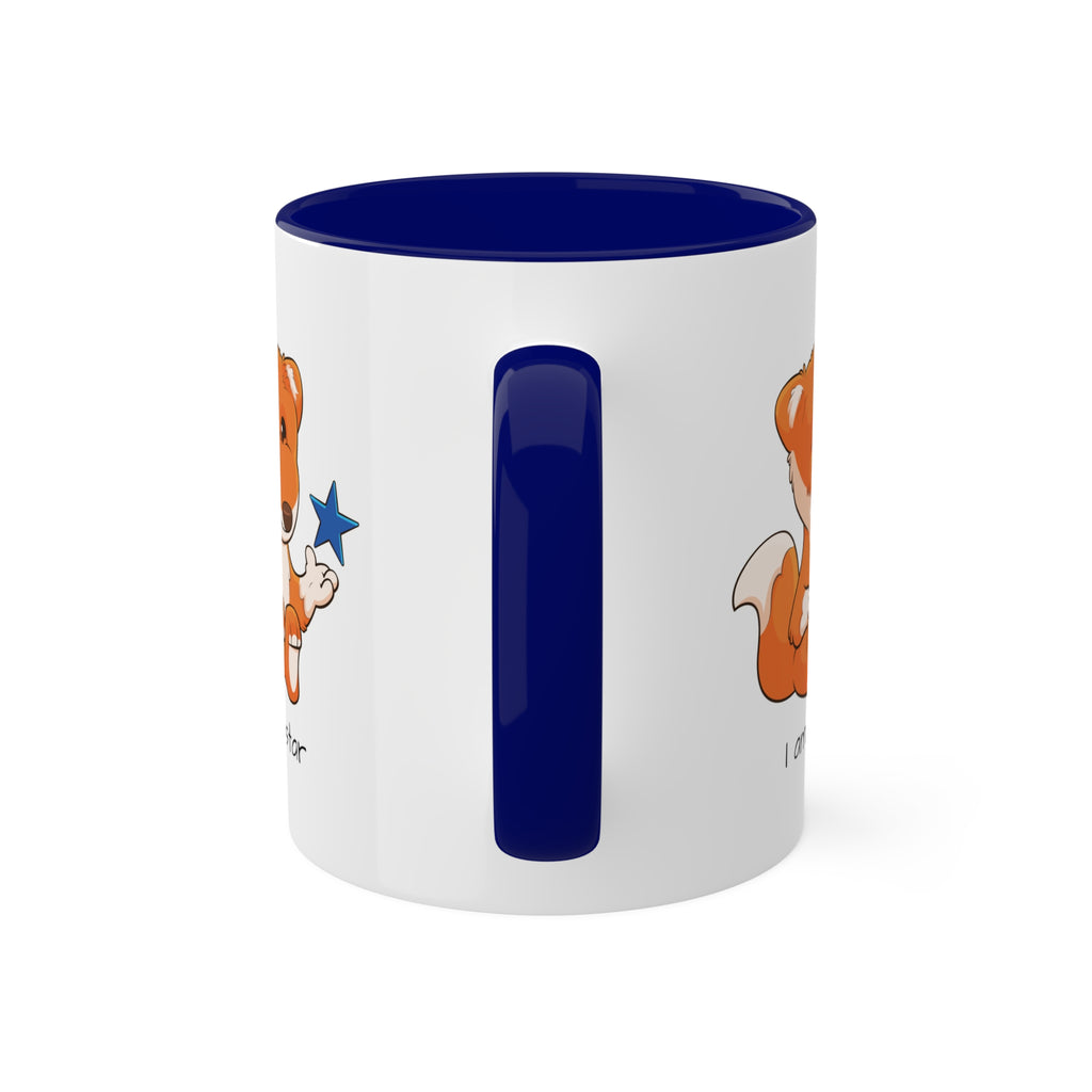 A white mug with a dark blue handle and interior and a picture of a fox that says I am a star.