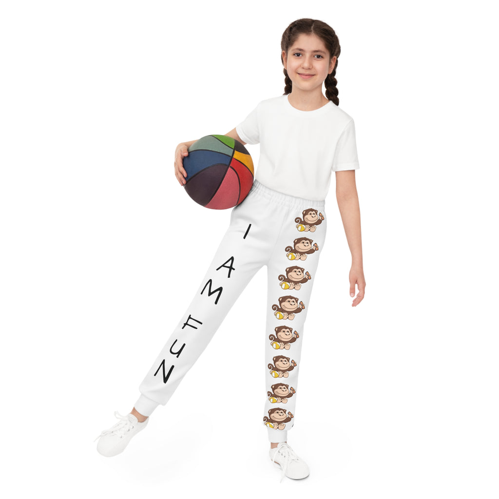 Front-view of a girl holding a basketball and wearing white sweatpants. The pants have a line of monkeys down the front left leg and the phrase "I am fun" down the front right leg.