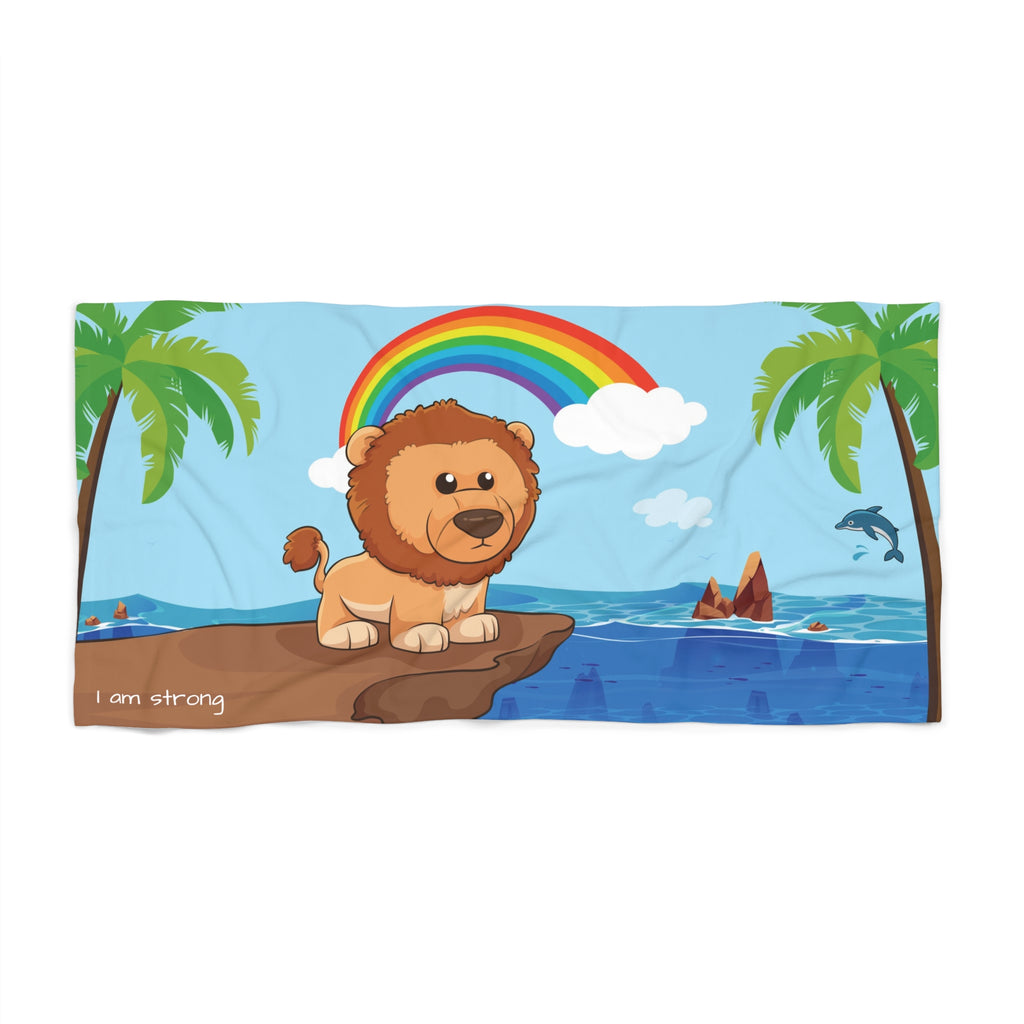 A 30 by 60 inch beach towel with a scene of a lion standing on a cliff over the ocean, a rainbow in the background, and the phrase "I am strong" along the bottom.