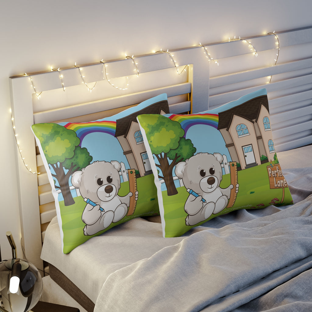 Two pillows sitting on a bed. The pillows have on pillowcases with a scene of a bear sitting in the yard of its house, a rainbow in the background, and the phrase "I am responsible" along the bottom.
