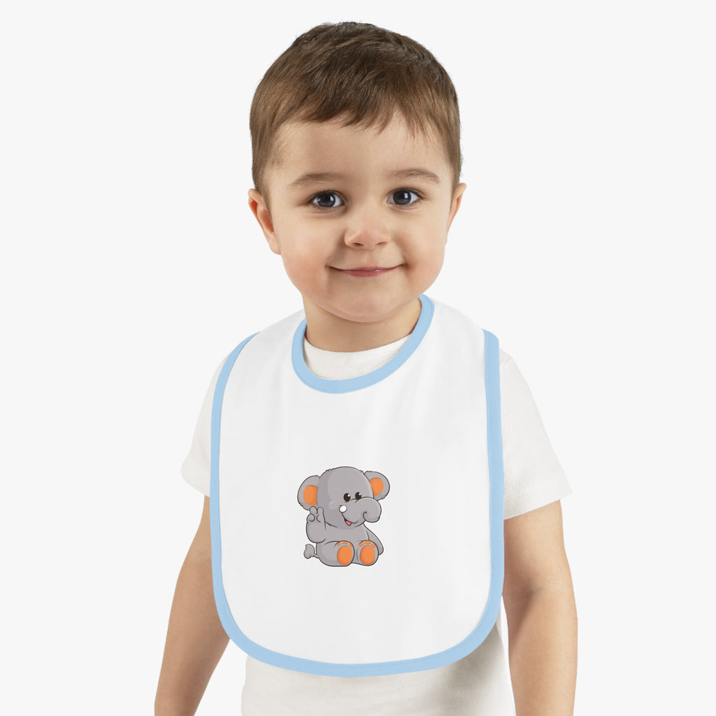 A little boy wearing a white baby bib with light blue trim and a small picture of an elephant.
