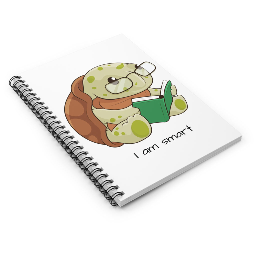 Side-view of a white spiral notebook laying closed, featuring a picture of a turtle that says I am smart.