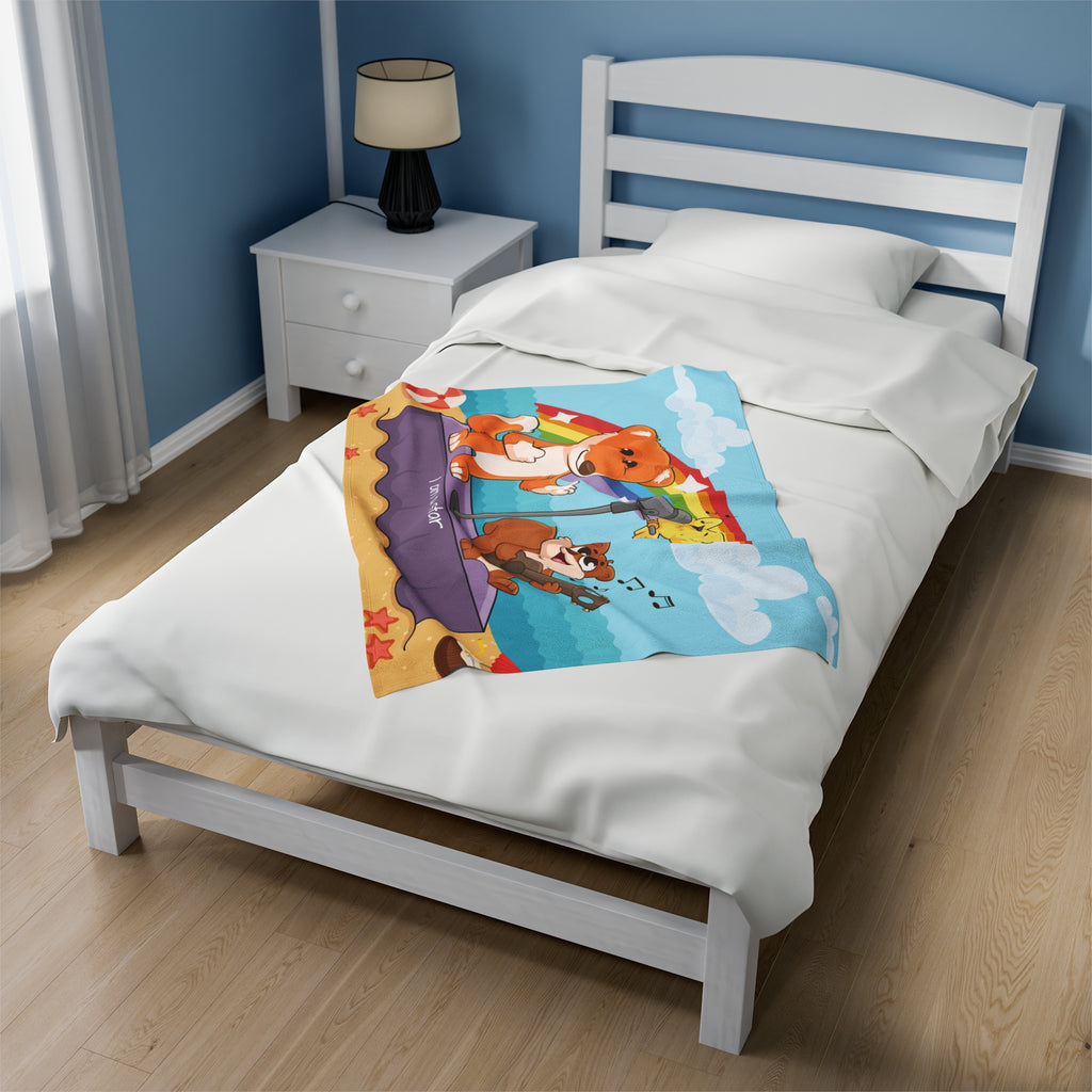 A 30 by 40 inch blanket on a twin-sized bed in a bedroom. The blanket has a scene of a fox singing with a bird and squirrel on a stage on the beach, a rainbow in the background, and the phrase "I am a star" along the bottom.