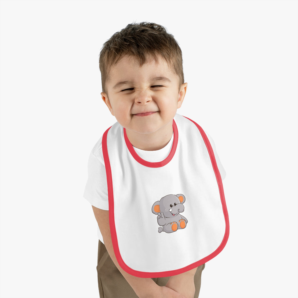 A little boy wearing a white baby bib with red trim and a small picture of an elephant.