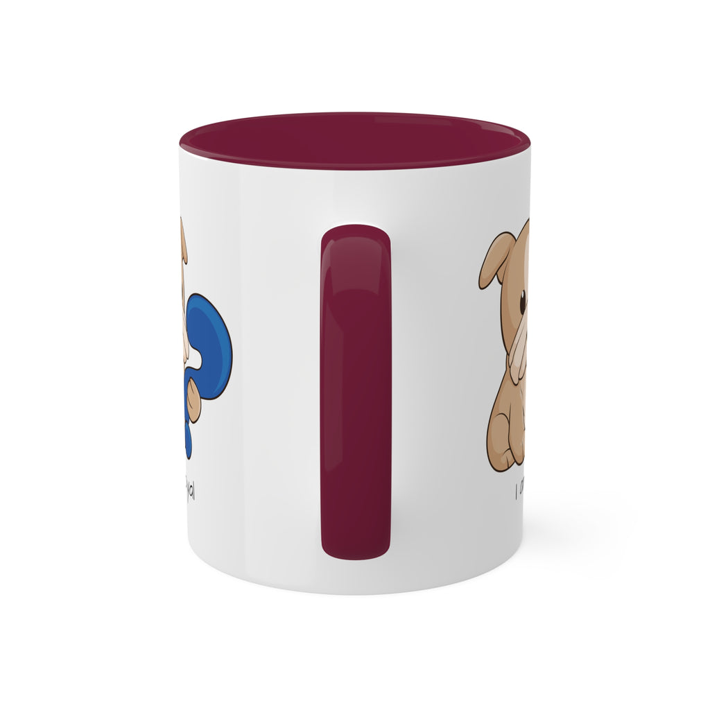 A white mug with a maroon handle and interior and a picture of a dog that says I am loyal.