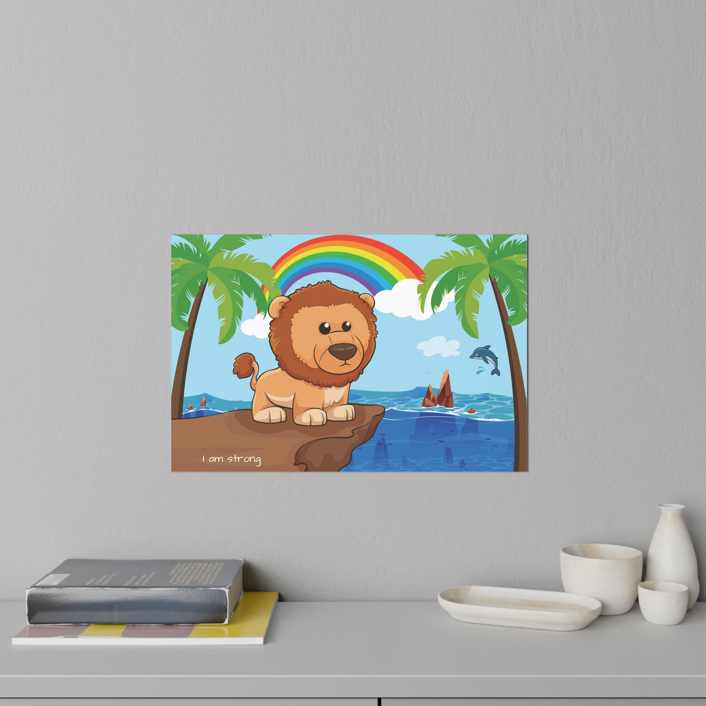 A 36 by 24 inch wall decal on a grey wall above a dresser and books. The wall decal has a scene of a lion standing on a cliff over the ocean, a rainbow in the background, and the phrase "I am strong" along the bottom.