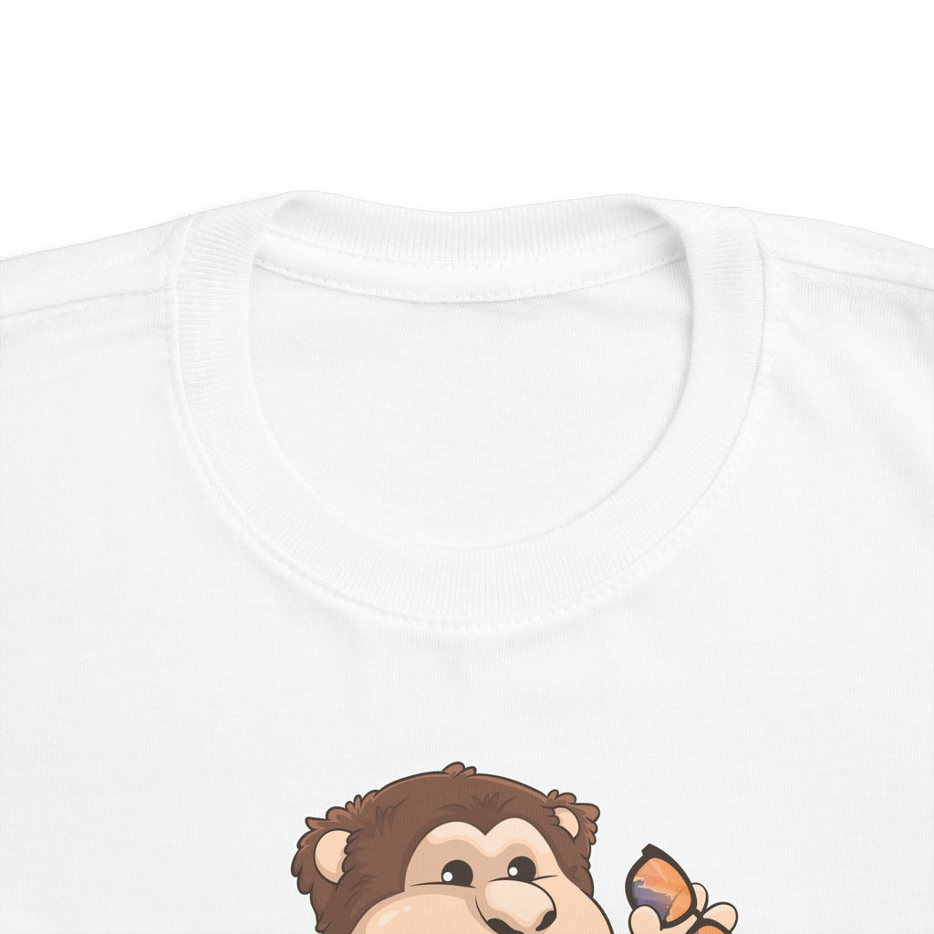 A close-up of the crew neckline of a short-sleeve white shirt with a picture of a monkey that says I am fun.