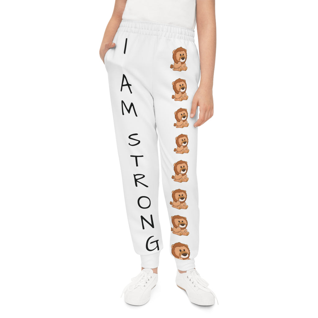Front-view of a girl wearing white sweatpants with a line of lions down the front left leg and the phrase "I am strong" down the front right leg.