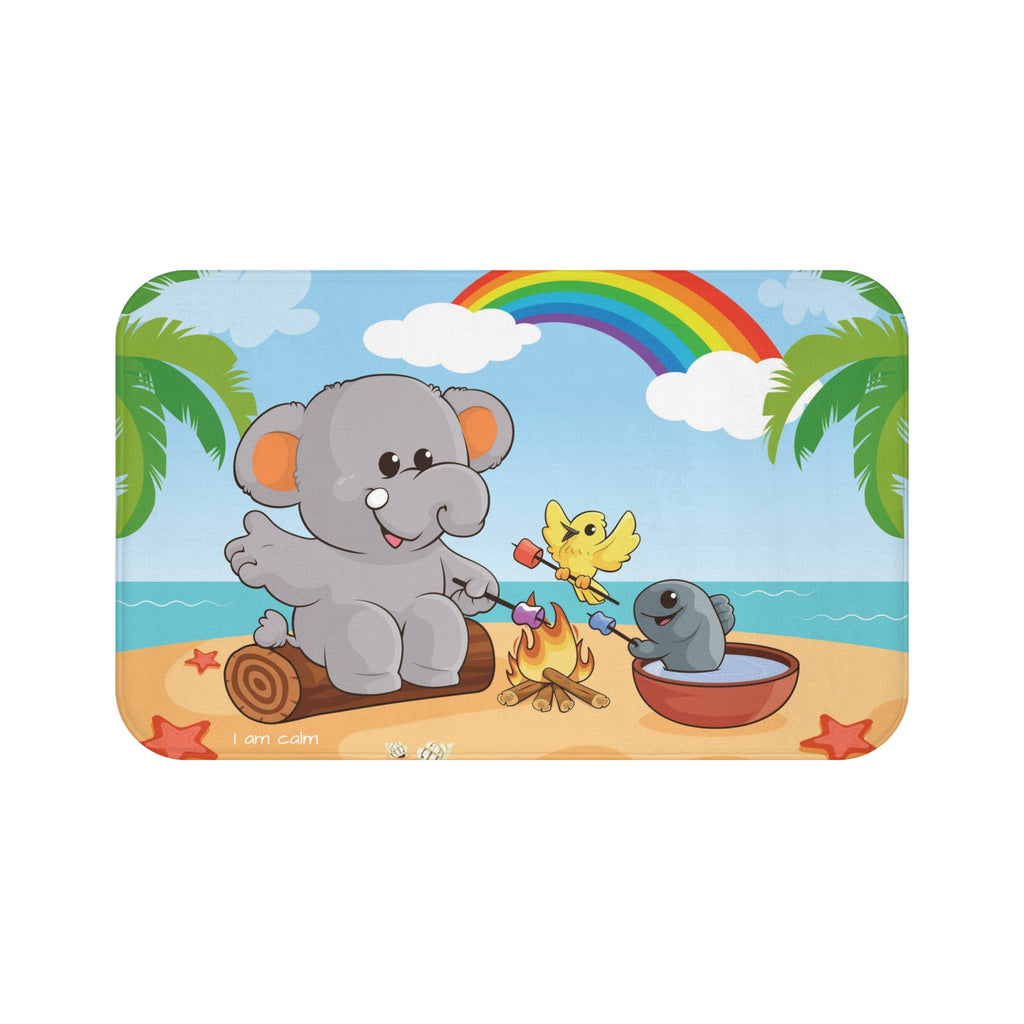 A 34 by 21 inch bath mat that has a scene of an elephant having a bonfire with a bird and fish on the beach, a rainbow in the background, and the phrase "I am calm" along the bottom.