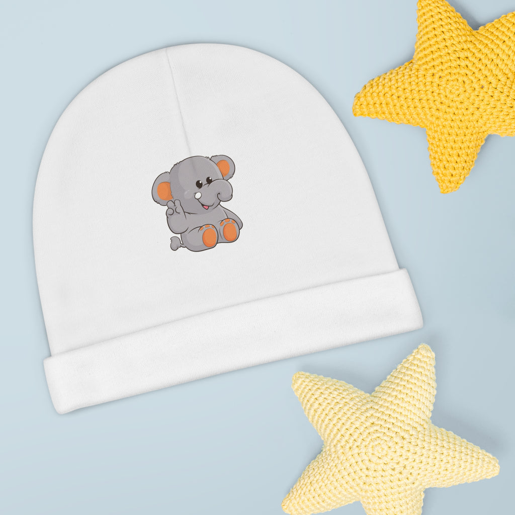 A white baby beanie with a small picture of an elephant. The beanie has the bottom edge folded up.