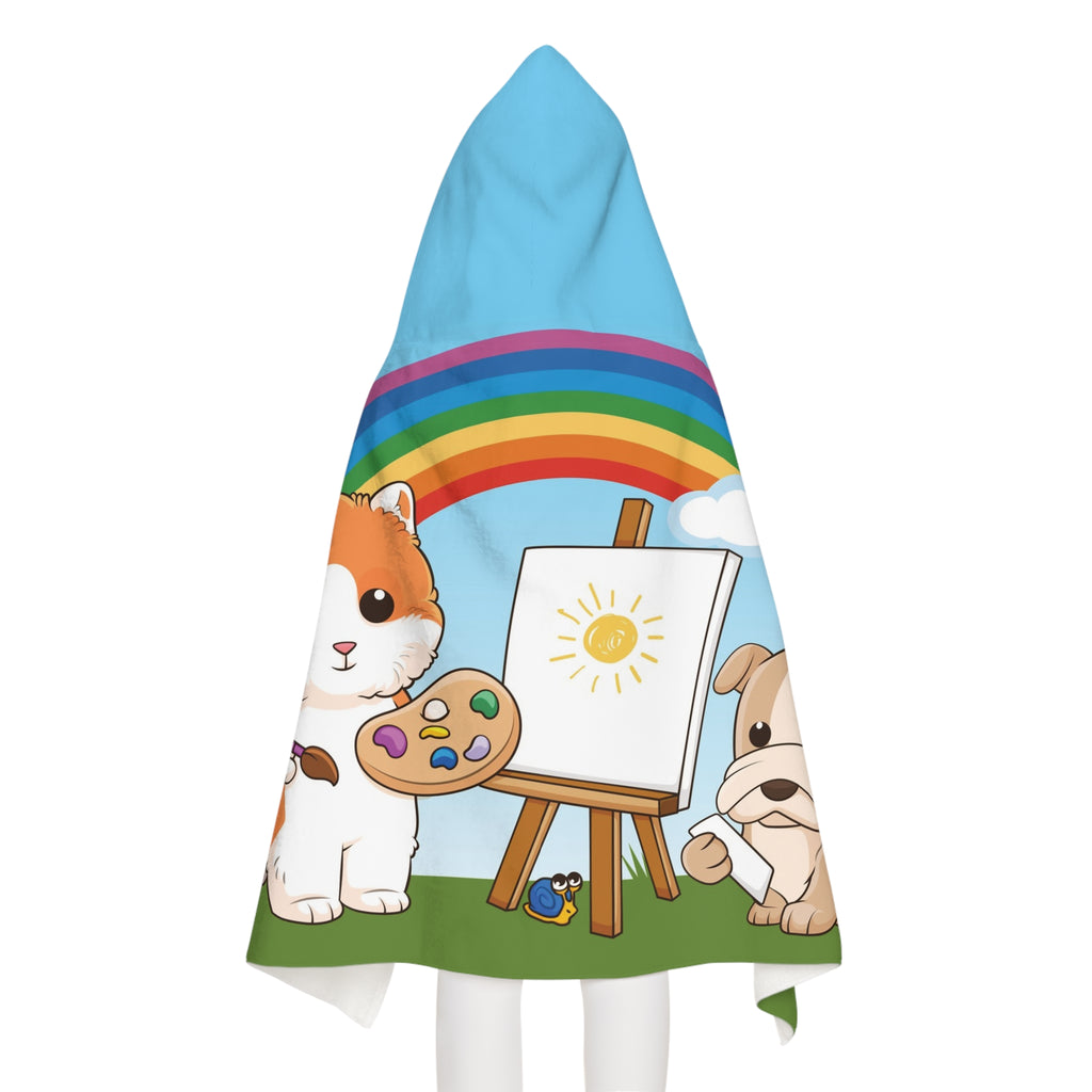 Back-view of a girl wearing a hooded towel. The towel has a scene of a cat painting on a canvas next to a dog, a rainbow in the background, and the phrase "I am creative" along the bottom.