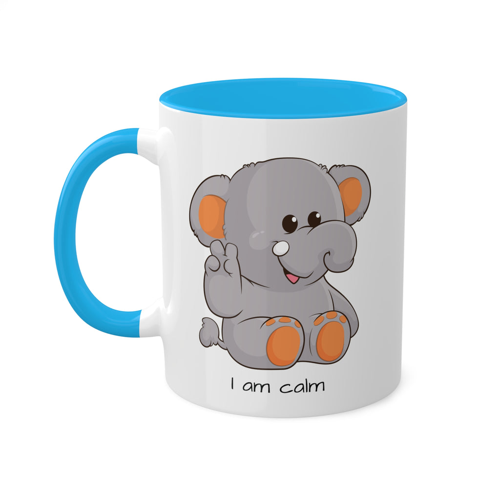 A white mug with a light blue handle and interior and a picture of an elephant that says I am calm.
