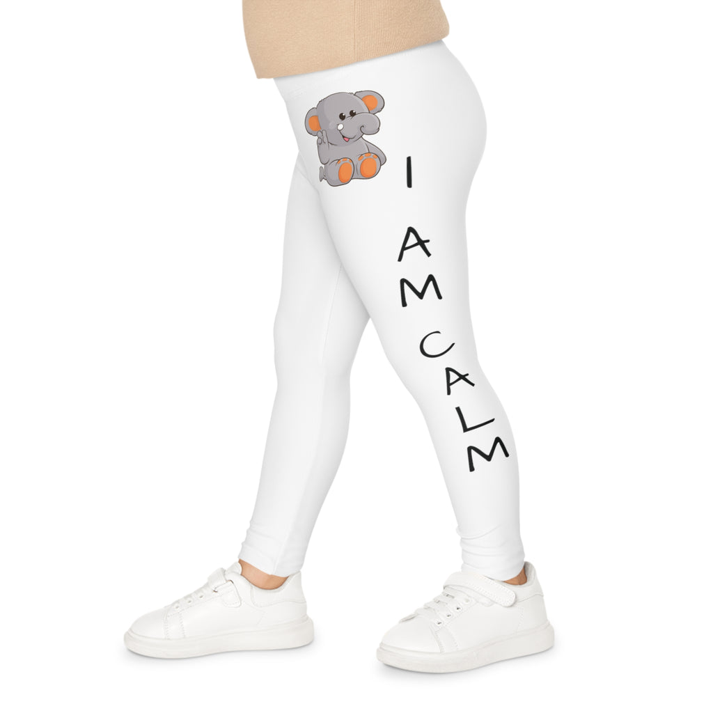 Left side-view of a child wearing white leggings with a picture of an elephant on the front left waist and the phrase "I am calm" read top to bottom on the side of the leg.