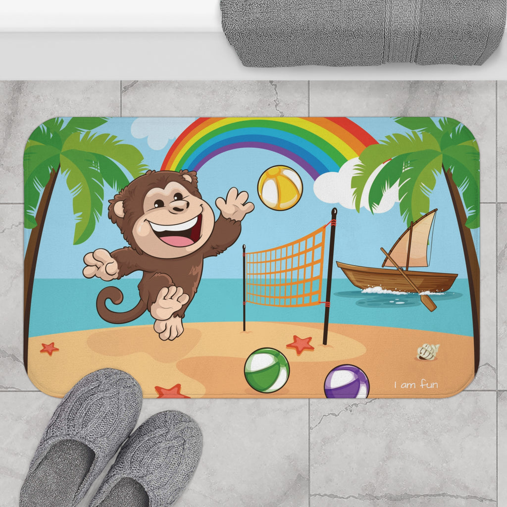 A 34 by 21 inch bath mat on the tiled floor of a bathroom. The bath mat has a scene of a monkey playing volleyball on a beach with a rainbow in the background and the phrase "I am fun" along the bottom.