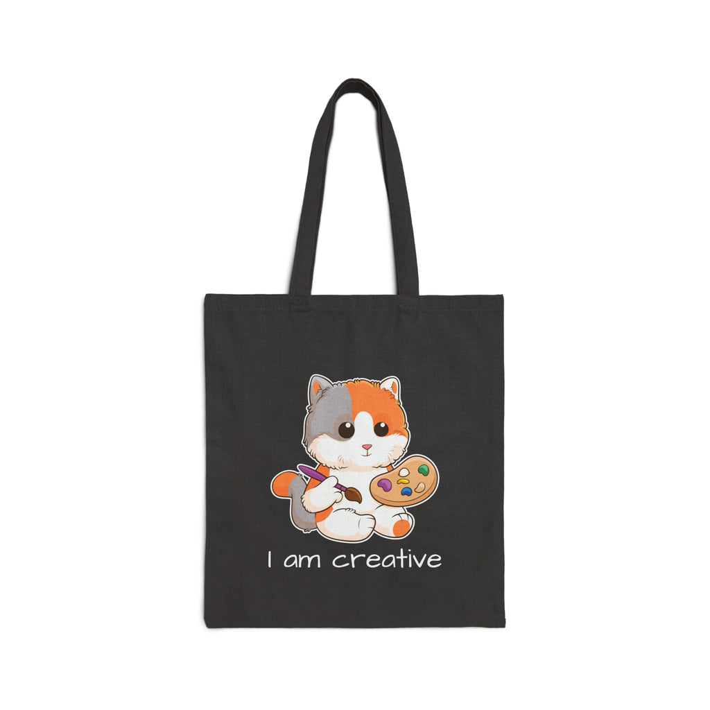 A black tote bag with a picture of a cat that says I am creative.