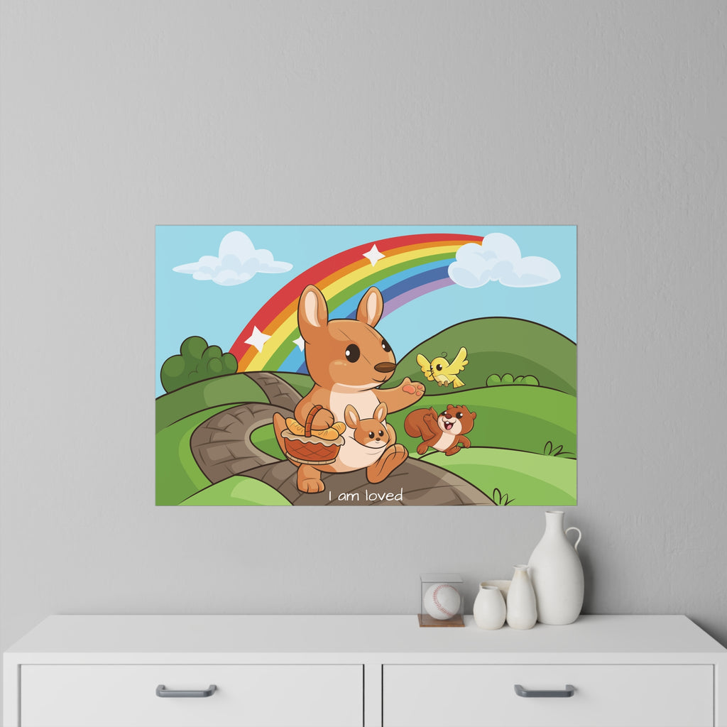 A 36 by 24 inch wall decal on a grey wall above a dresser. The wall decal has a scene of a kangaroo walking along a path through rolling hills, a rainbow in the background, and the phrase "I am loved" along the bottom.