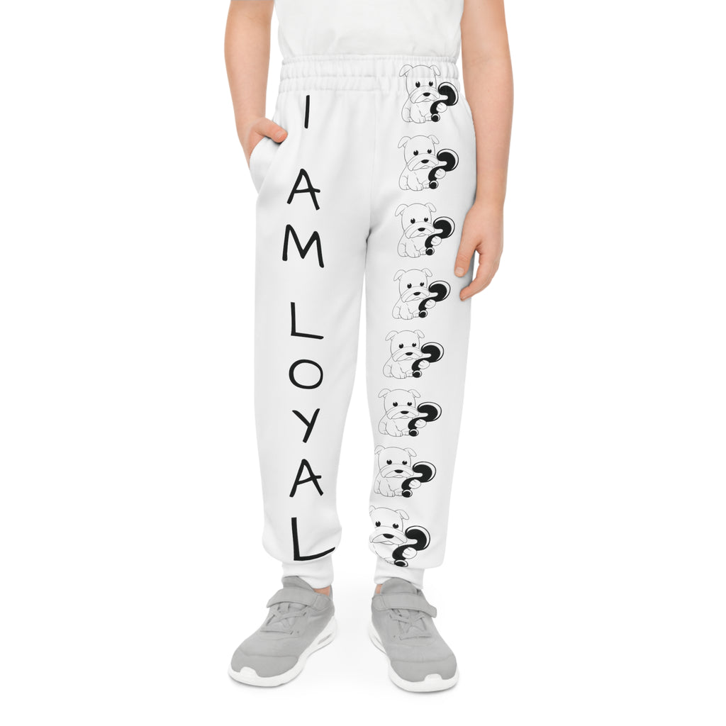 Front-view of a boy wearing white sweatpants with a line of black and white dogs down the front left leg and the phrase "I am loyal" down the front right leg.