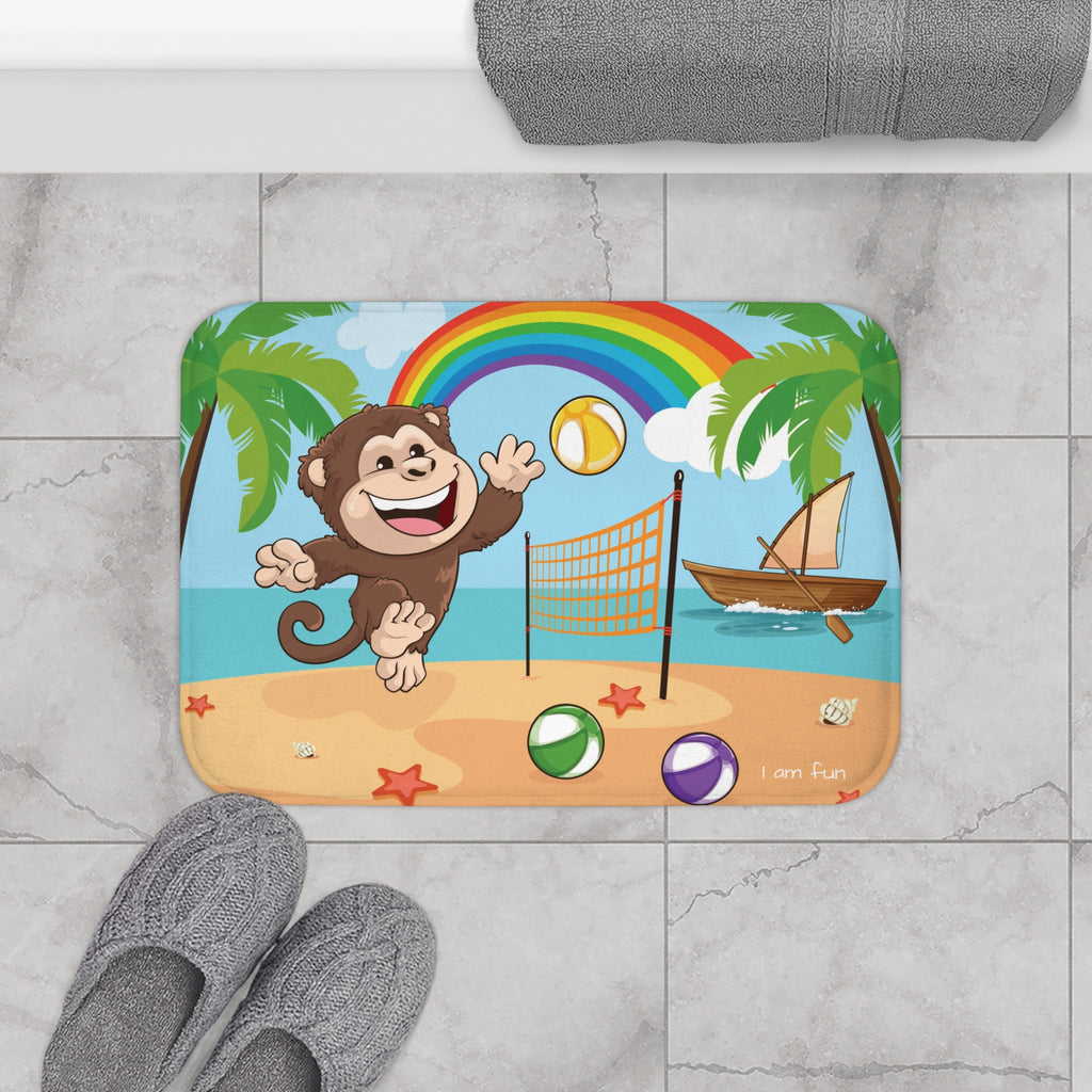 A 24 by 17 inch bath mat on the tiled floor of a bathroom. The bath mat has a scene of a monkey playing volleyball on a beach with a rainbow in the background and the phrase "I am fun" along the bottom.