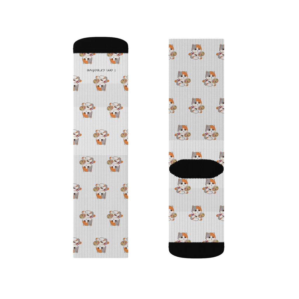 A pair of crew-length white socks with black toes and heels and a repeating pattern of a cat.
