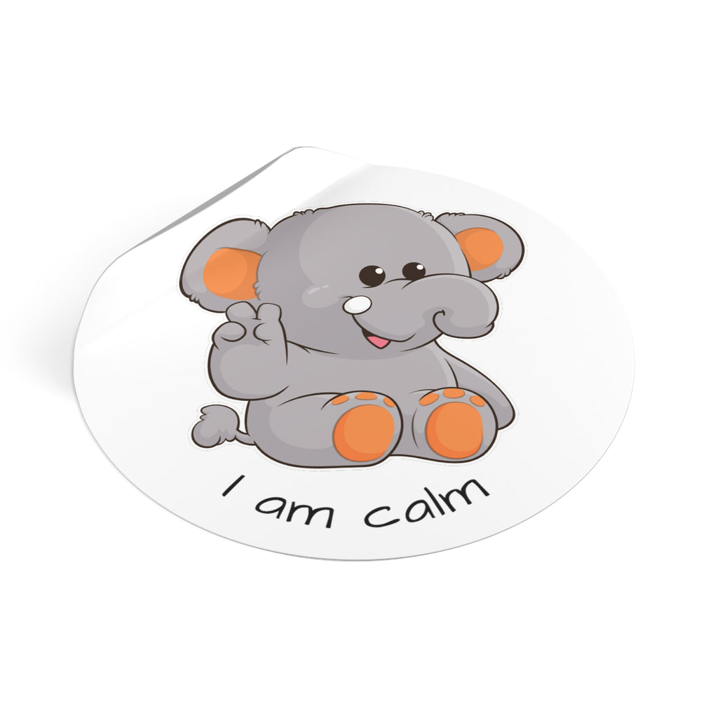 A 3 by 3 inch round white vinyl sticker with a picture of an elephant that says I am calm. The edge of the sticker is curled up.