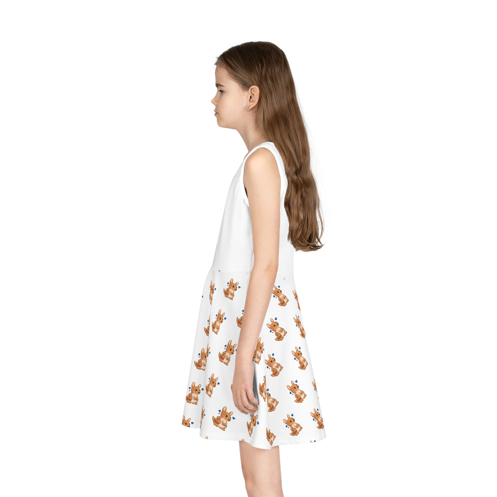 Left side-view of a girl wearing a sleeveless white dress with a white top and a repeating pattern of a kangaroo on the skirt.